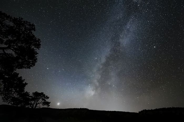 The Milky Way over a dark landscape
